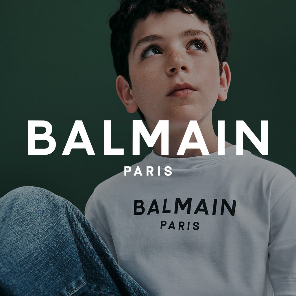 Child wearing a Balmain Paris sweatshirt with the brand name displayed.